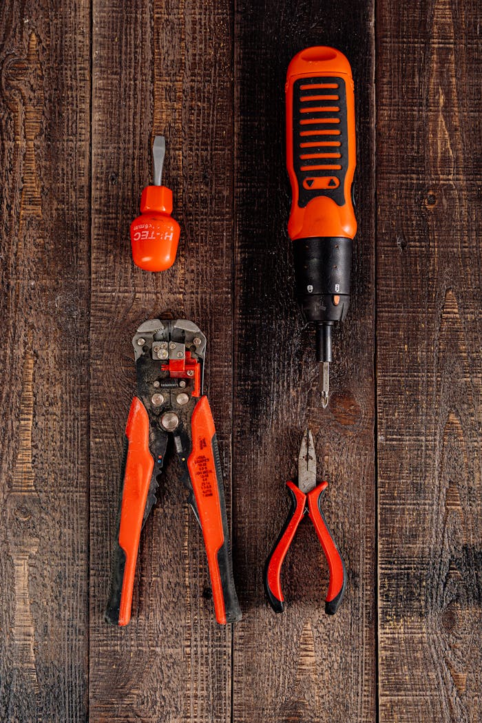 creative Flat lay view of various red tools on a wooden surface, perfect for DIY and workshop themes.